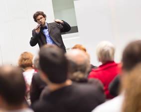 Student presenting with a microphone in front of a crowd